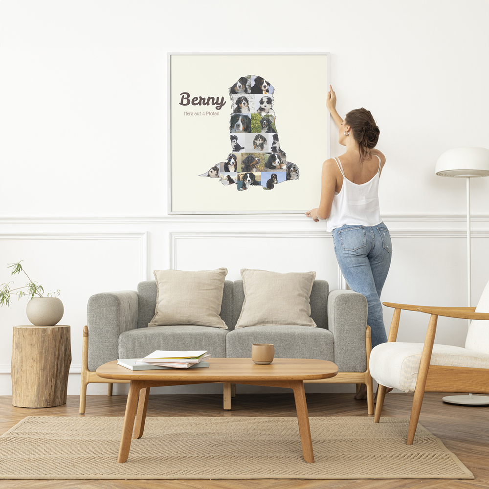 Fotocollage van een zittende berner sennenhond met naam, in een witte lijst boven een grijze bank in een lichte woonkamer