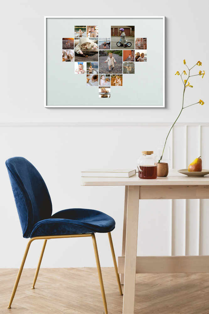 Hartvormige collage met kinderfoto’s in een witte lijst boven een eettafel naast een blauwe stoel