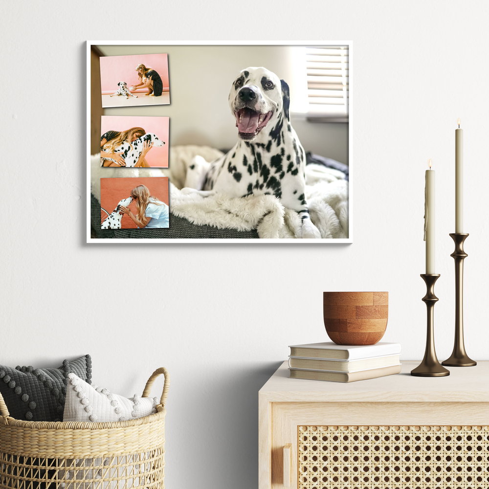 Fotocollage van een dalmatiër in een witte lijst boven een houten kast, naast een mand en kandelaars