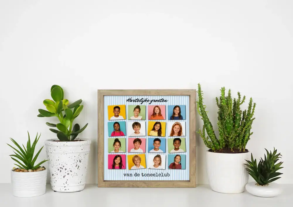Schoolfotocollage met 16 kinderportretten en groettekst in houten lijst, tussen planten op een wit bureau
