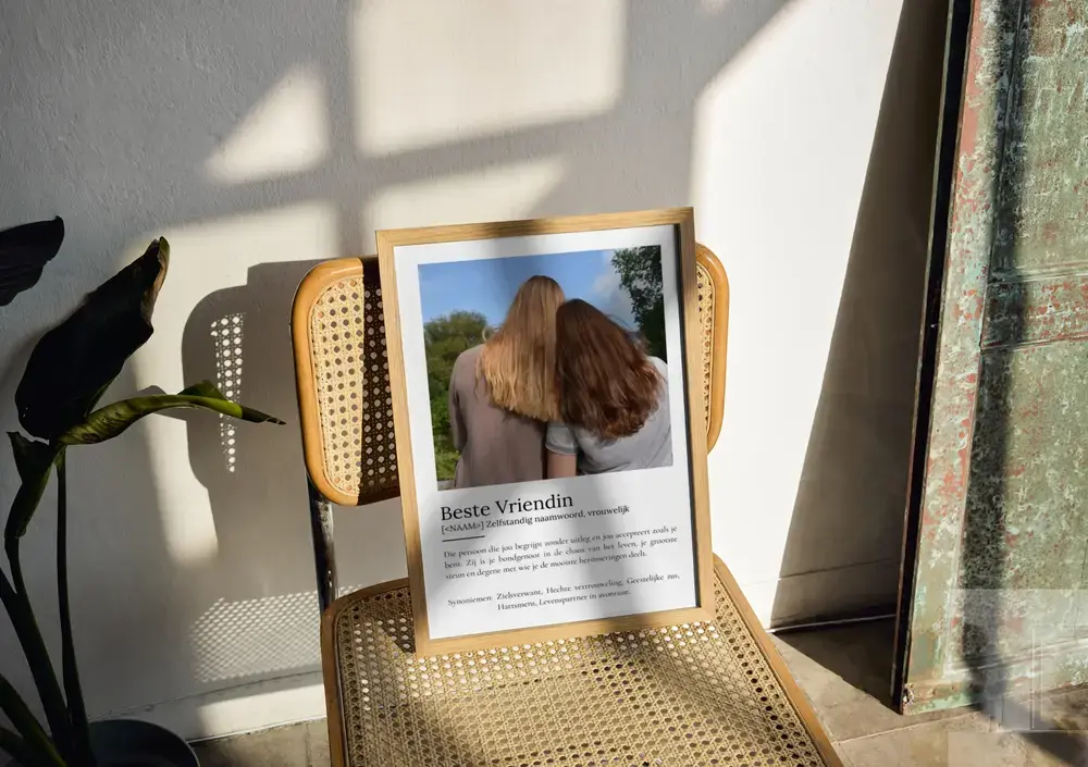 Definitieposter voor een beste vriendin met foto en tekst, in een houten lijst op een stoel in het zonlicht