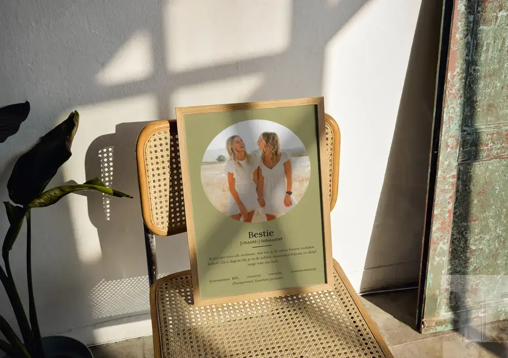 Groene fotoposter met definitie in houten lijst op een rotan stoel, een origineel cadeau voor een vriendin