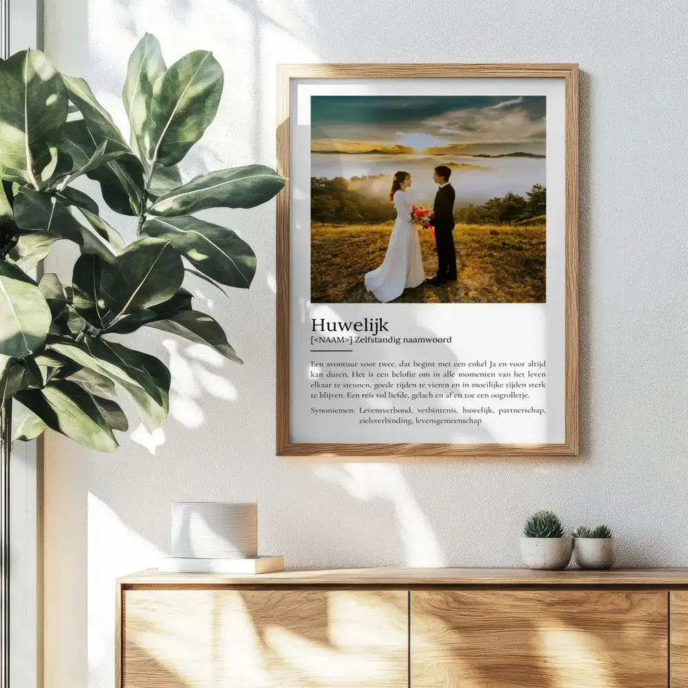 Definitieposter over het huwelijk met grote trouwfoto in houten lijst, aan de muur boven een dressoir