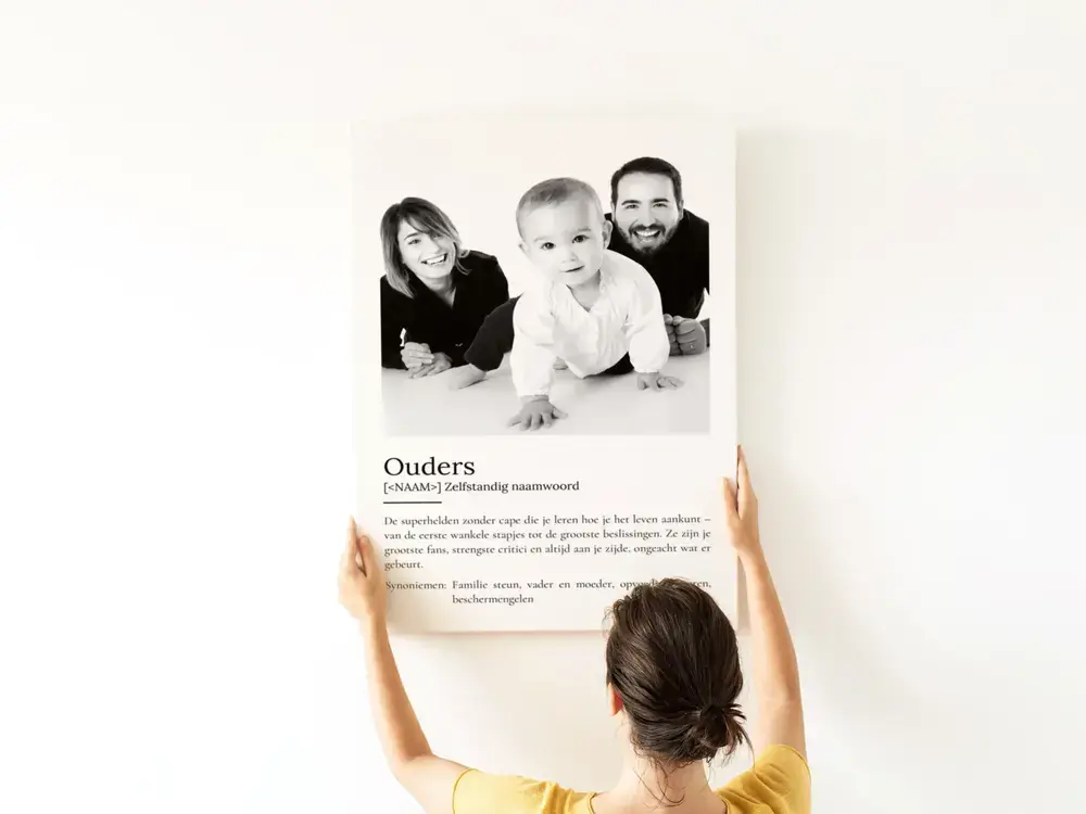 Poster in woordenboekstijl met zwart-witgezinsfoto aan een witte muur, als persoonlijk cadeau voor papa en mama