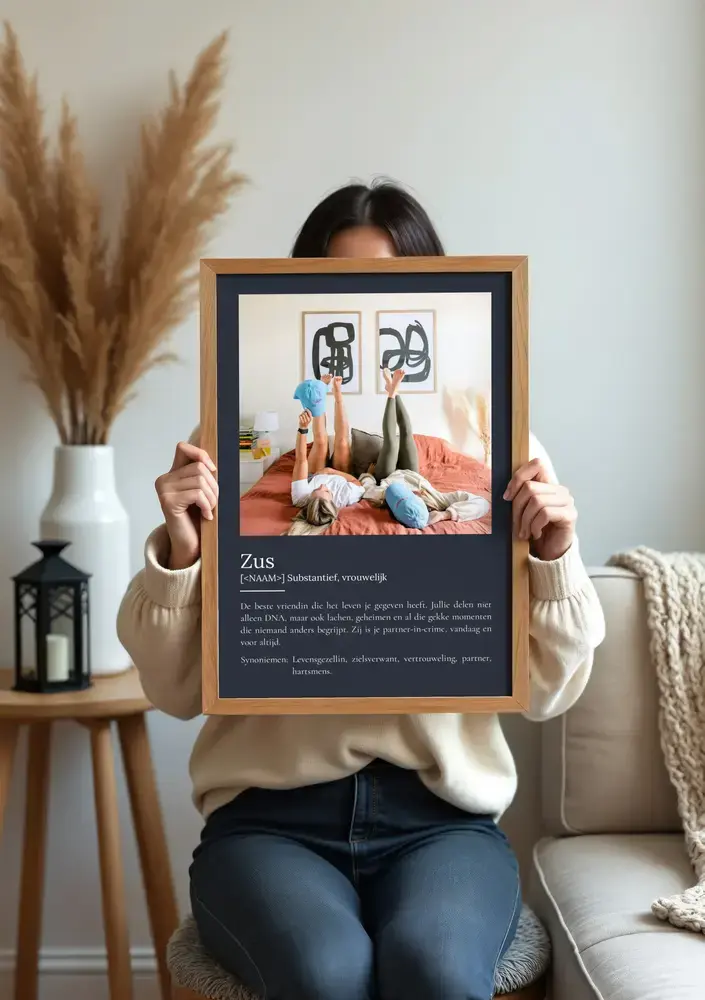 Definitieposter voor een zus met één foto en witte tekst op donkergrijs, in een houten lijst bij de bank