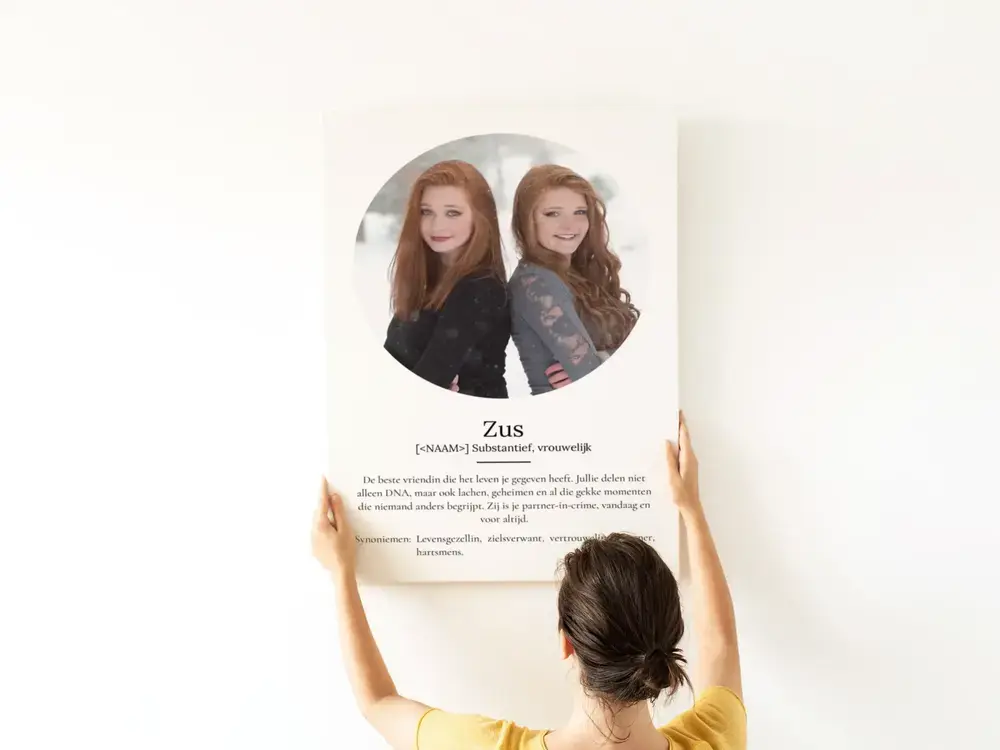 Poster in woordenboekstijl voor een zus, met rond portret en persoonlijke tekst op wit, aan een lichte muur