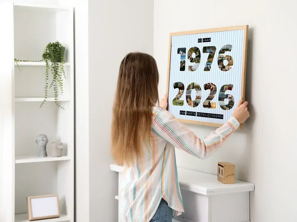 Fotocollage met jaartallen in houten lijst aan een witte muur, als cadeau voor een 50-jarig jubileum