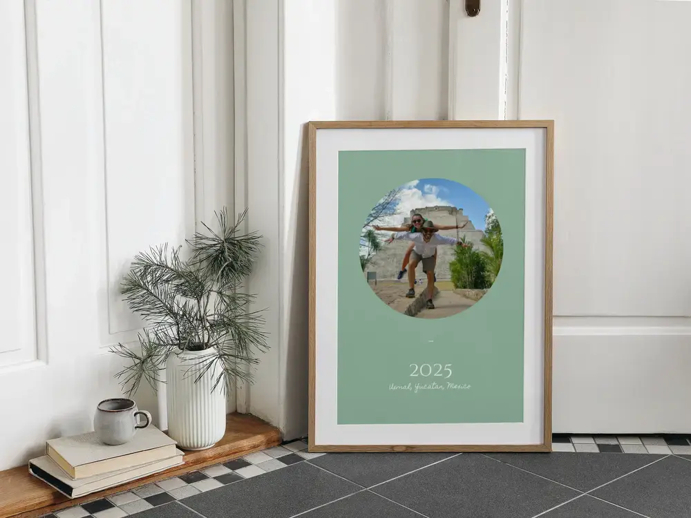 Ingelijste reisposter met ovale foto op saliegroen, op de vloer als cadeau ter herinnering aan de vakantie