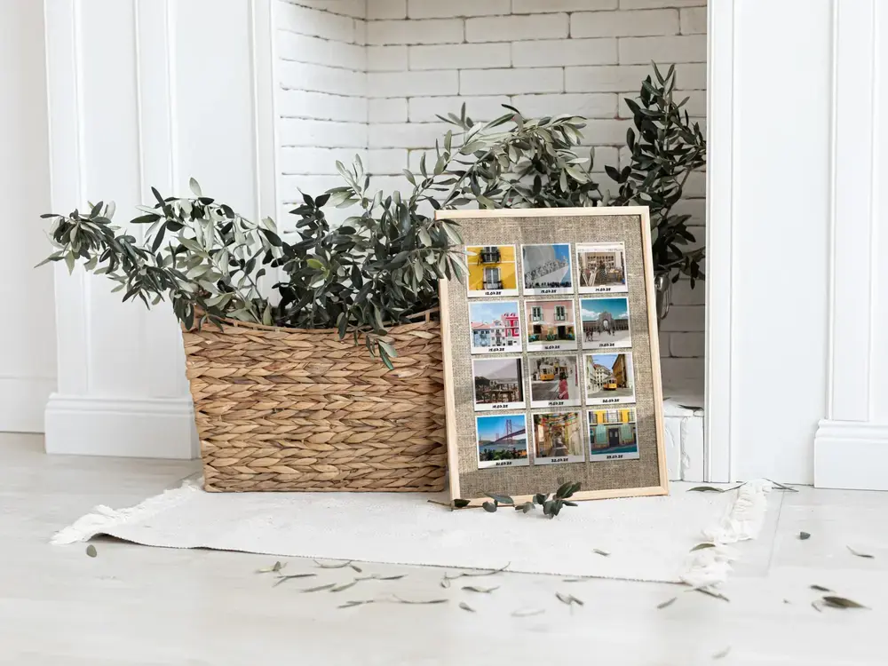 Ingelijste Lissabon-collage met twaalf polaroidfoto’s op de vloer naast een plantenmand, een persoonlijk vakantiecadeau