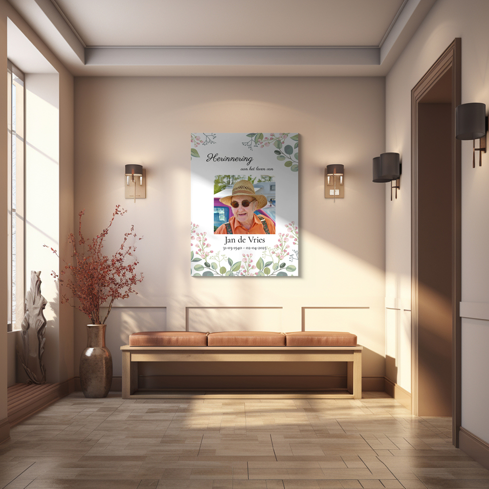 Rouwfoto op een poster met bloemenrand, aan de muur boven een houten bankje in een lichte hal