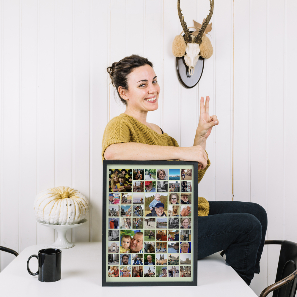 Familiecollage in een zwarte lijst op een witte tafel, met kinderfoto's uitgelicht, een mooi cadeau voor opa en oma
