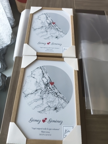Twee ronde stadskaarten met hartjes in naturel houten lijsten op een tafel, als romantisch cadeau